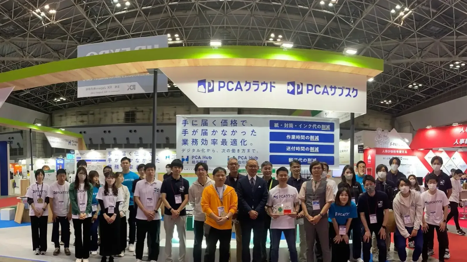 HR EXPO2024のPCAクラウド・PCAサブスクのブース前で、AZentとピー・シー・エーのメンバーが並んで立っている